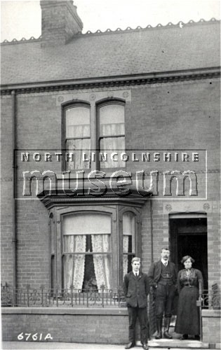 12 Sheffield Street, Scunthorpe, with the owners Charles Herbert Bird, Sarah Ellen Bird and their son Wilfred outside 	