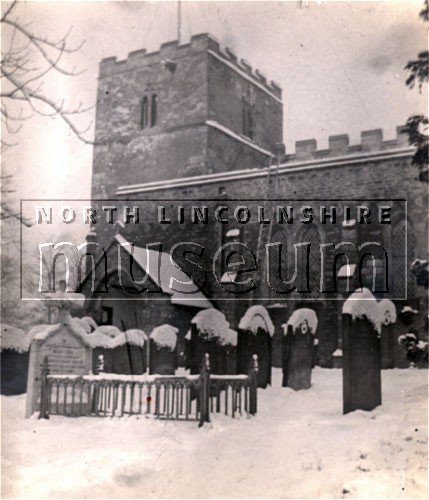 The tower and part of the graveyard of St. Lawrence's parish Church, Frodingham, Scunthorpe, taken in the snow 	