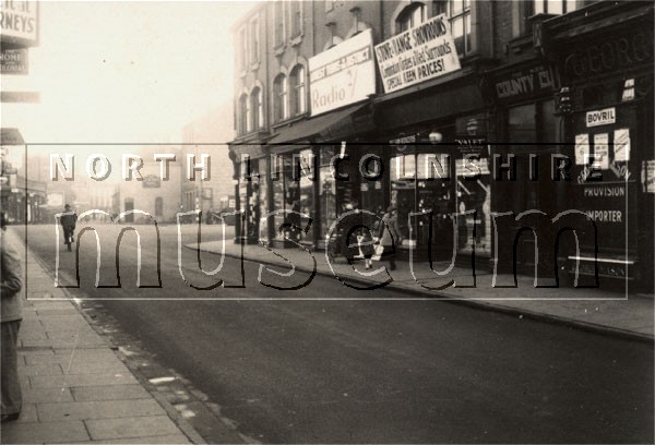 Scunthorpe High Street looking east towards the Blue Bell Hotel and the Enterprise and Silver Dawn bus company bus station in the 1930's 	