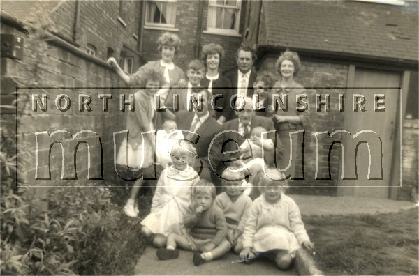 Kiddle family group behind their house in Frodingham Road, Scunthorpe, opposite Holy Souls' Catholic church, c.1963 	