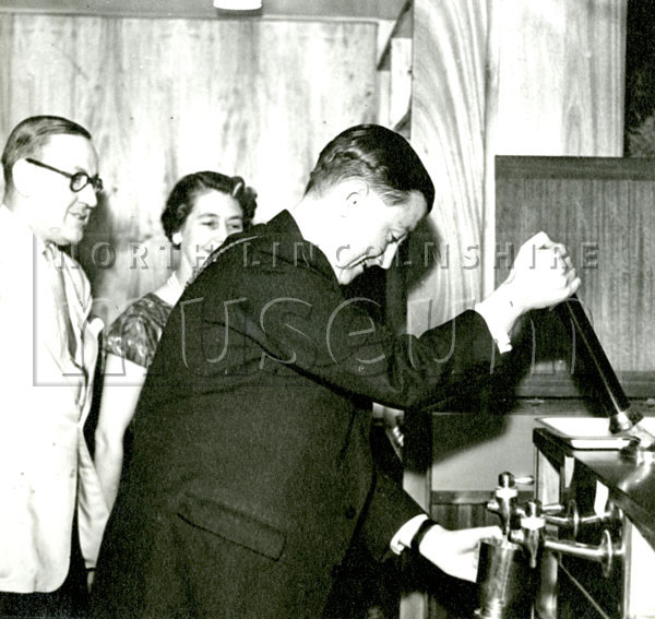 Mayor Gerard McQuade pulling a pint at an unknown location, 1957-1958.